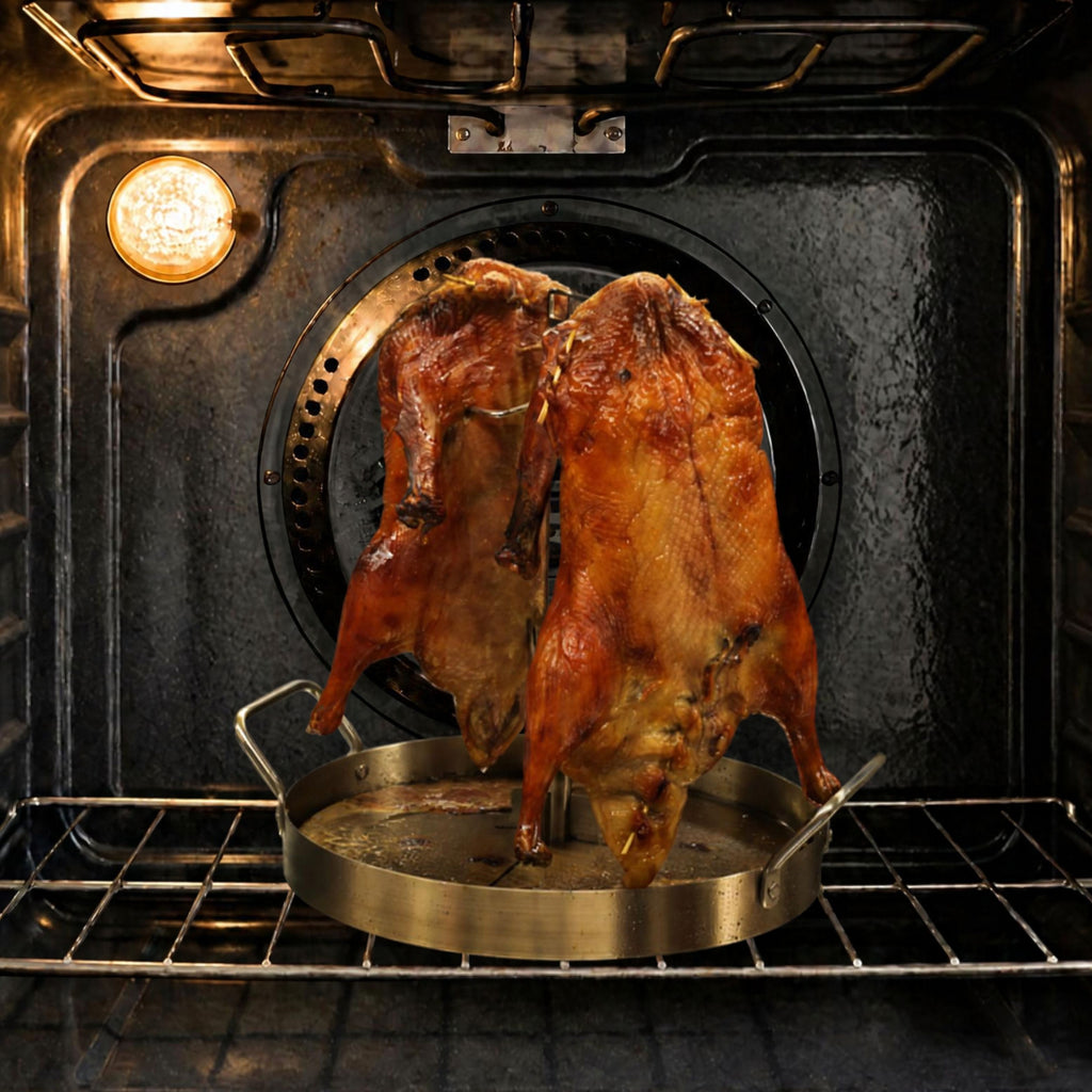 Two Peking duck roasting vertically in the UpRoaster inside a home oven